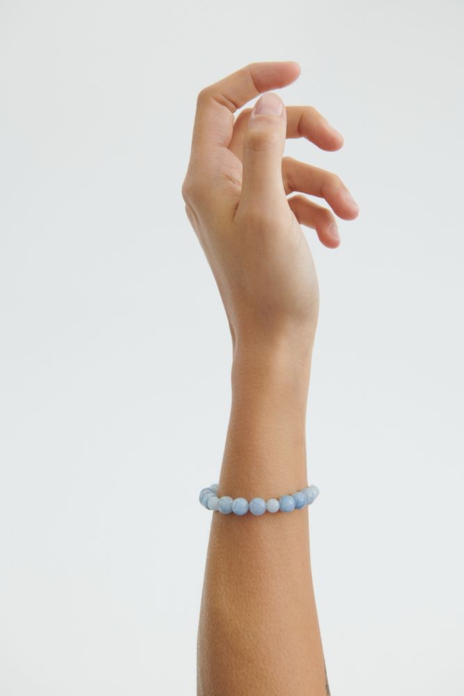 Frau trägt Blue Sky Armband aus vergoldetem Silber mit blauen Achatsteinen am Handgelenk