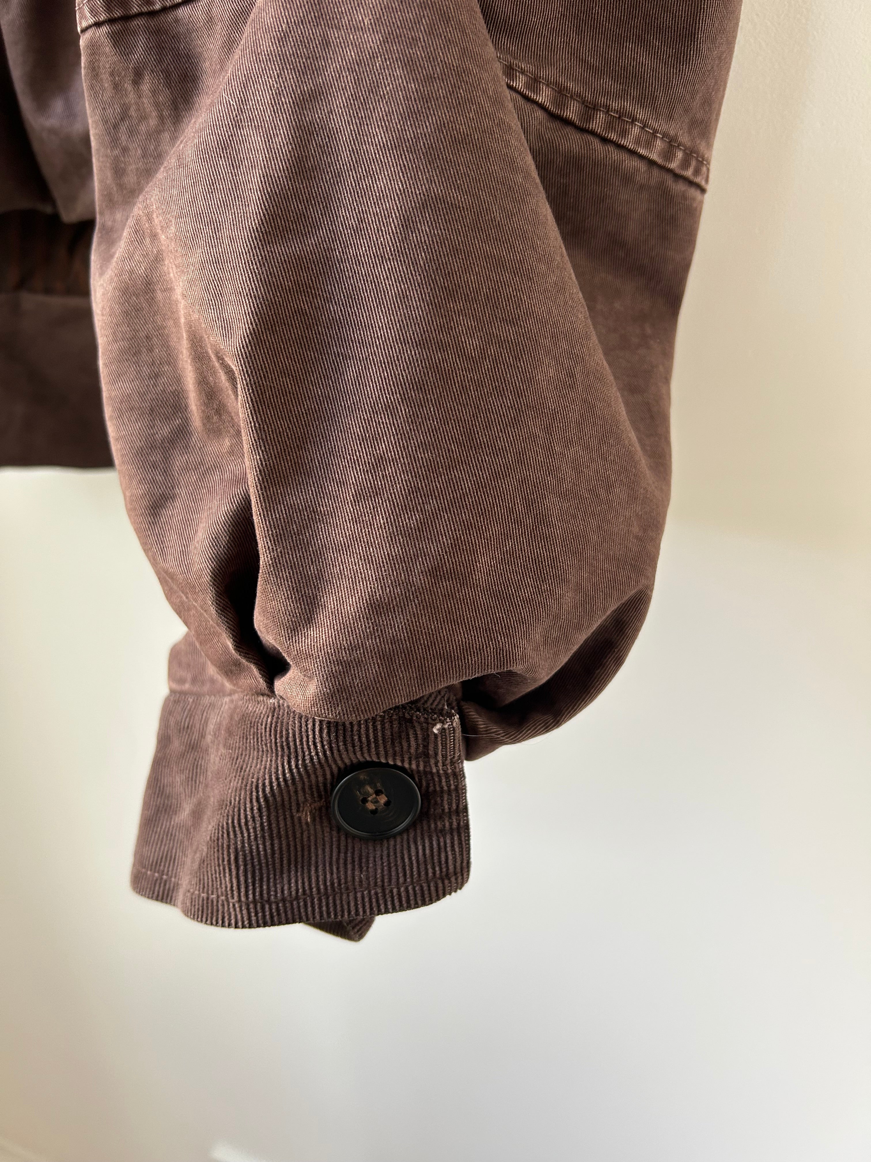 Nahaufnahme der Babycord-Manschette am Ärmelabschluss der Herbstjacke Dunkelbraun, Knopf-Detail zur Größenanpassung