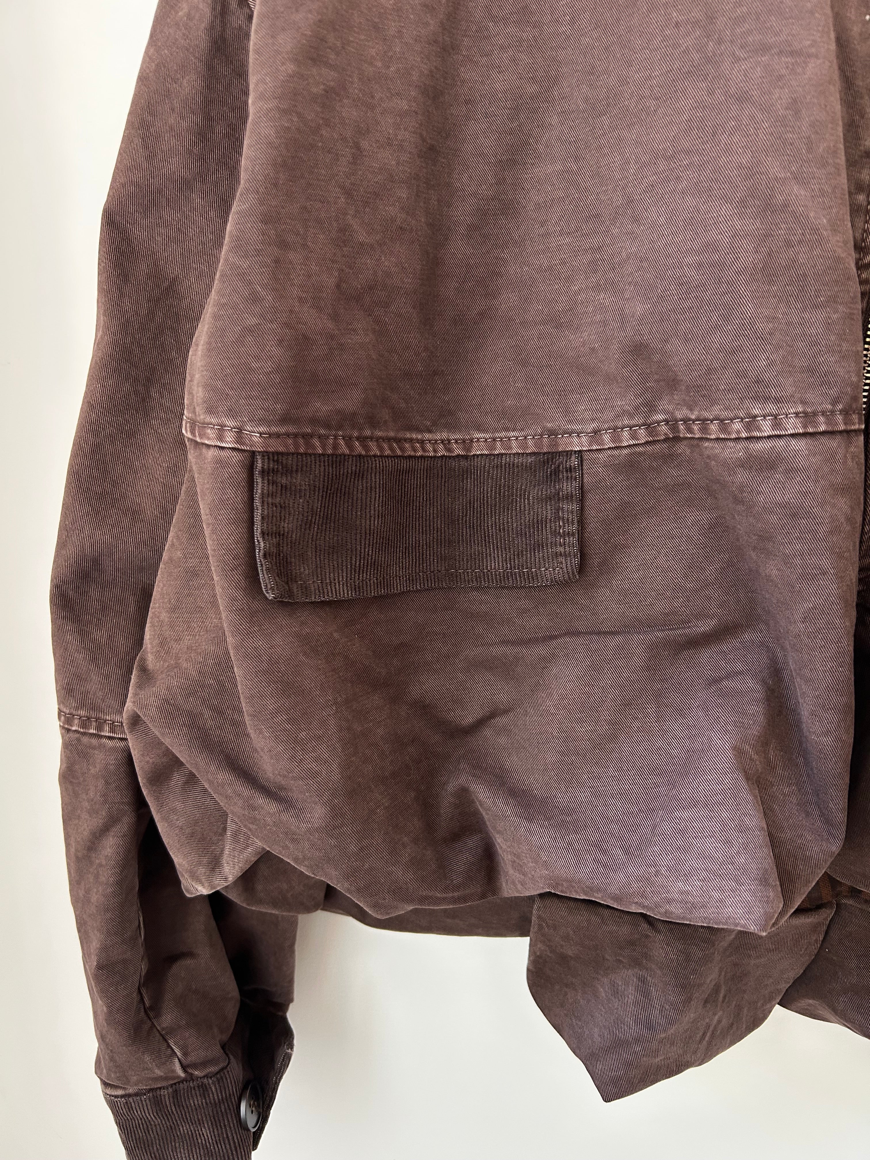 Nahaufnahme der Tasche mit Babycord-Lasche an der voluminösen Herbstjacke Dunkelbraun