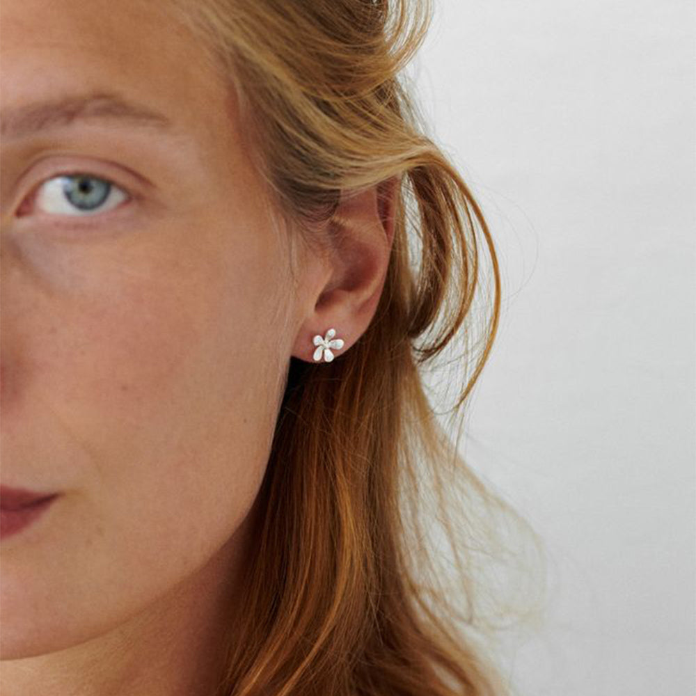 Model mit Wild Poppy Ohrsteckern aus recyceltem Silber, Nahaufnahme, filigraner nachhaltiger Silberschmuck von Pernille Corydon