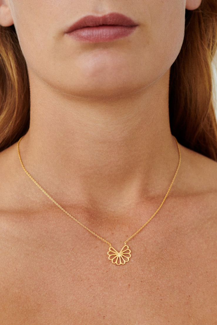 Model kombiniert die Small Bellis Halskette gold mit weiteren Ketten – feminines Layering im skandinavischen Stil