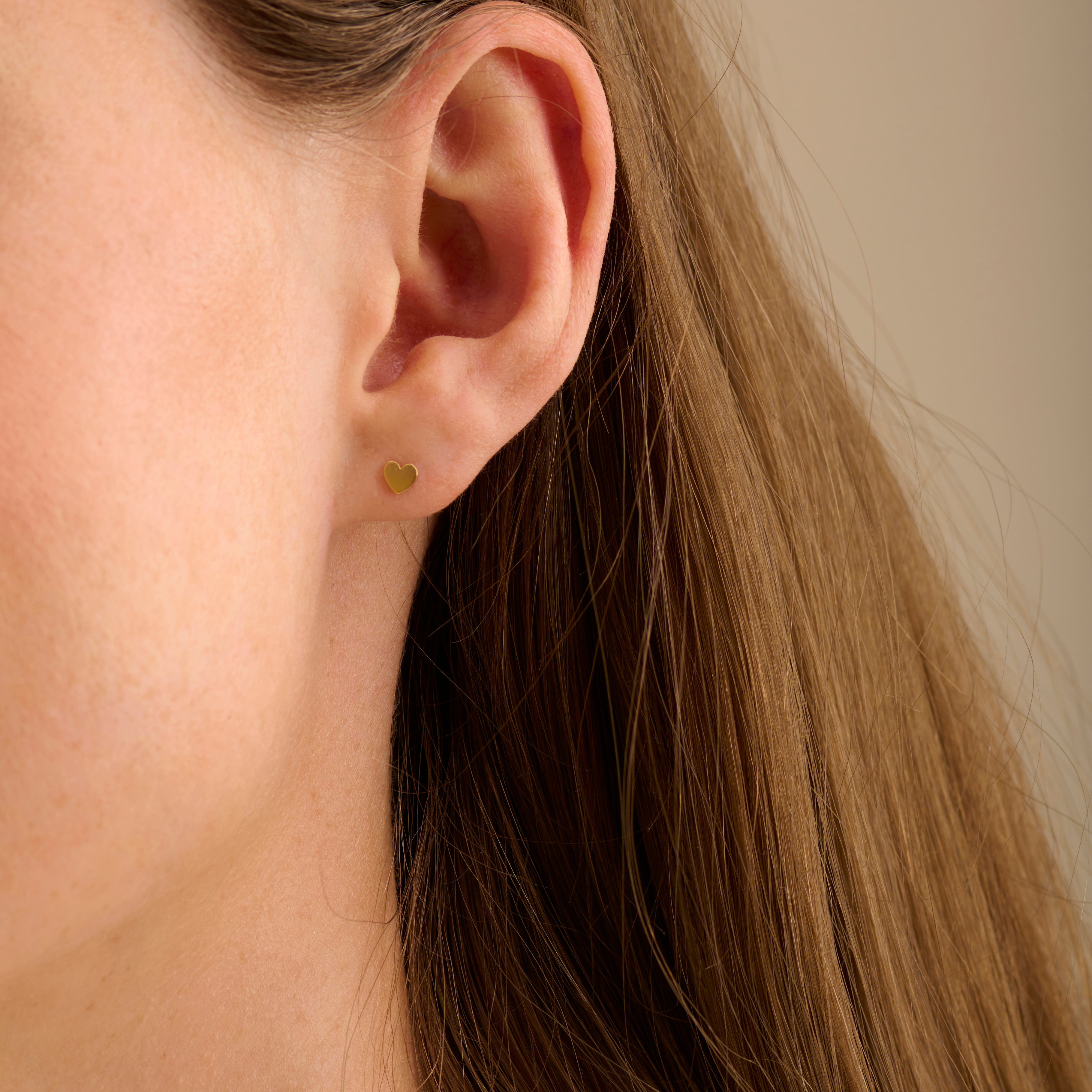 Model trägt Mini Heart Ohrstecker Gold 3,5 mm von Pernille Corydon