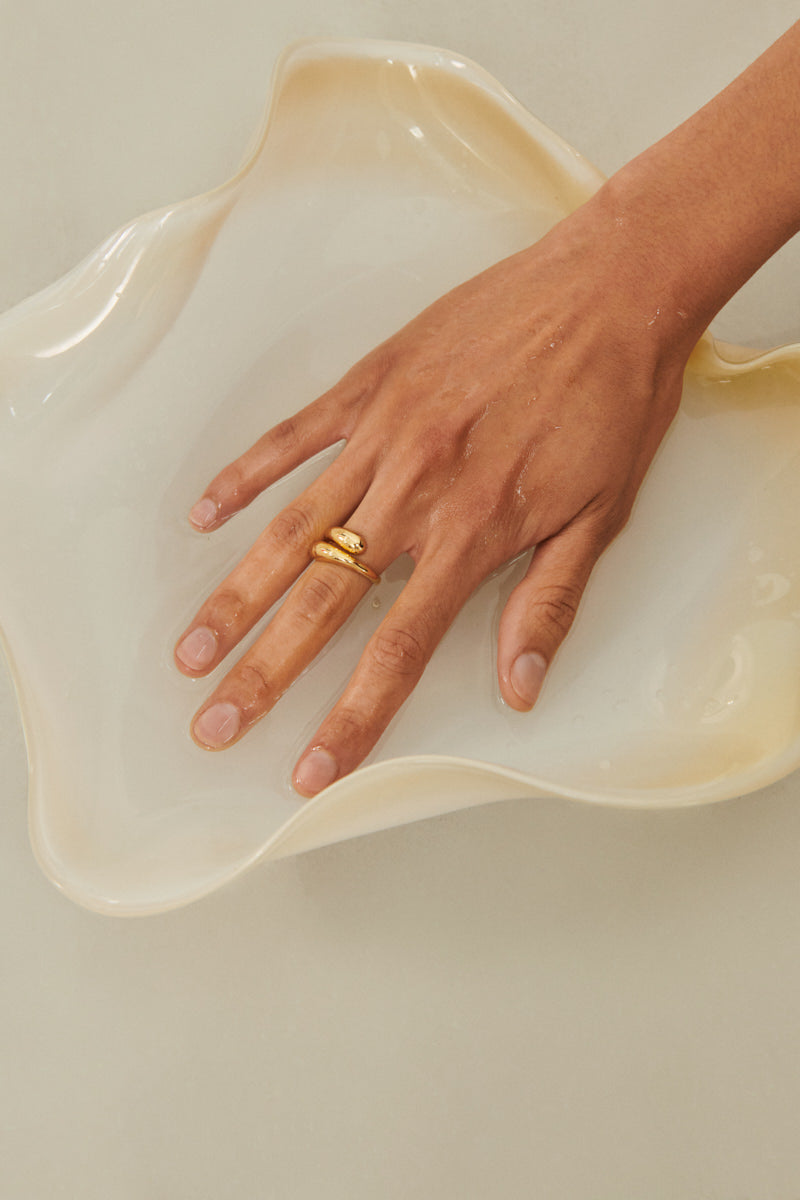 Model trägt den Rain Ring – Gold von Pernille Corydon in Kombination mit anderem Schmuck
