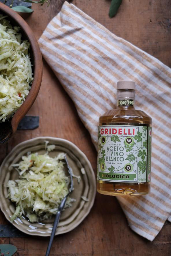 Gridelli Aceto di Vino Bianco auf Küchentisch neben frischem Salat