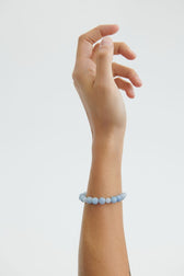 Frau trägt Blue Sky Armband aus vergoldetem Silber mit blauen Achatsteinen am Handgelenk