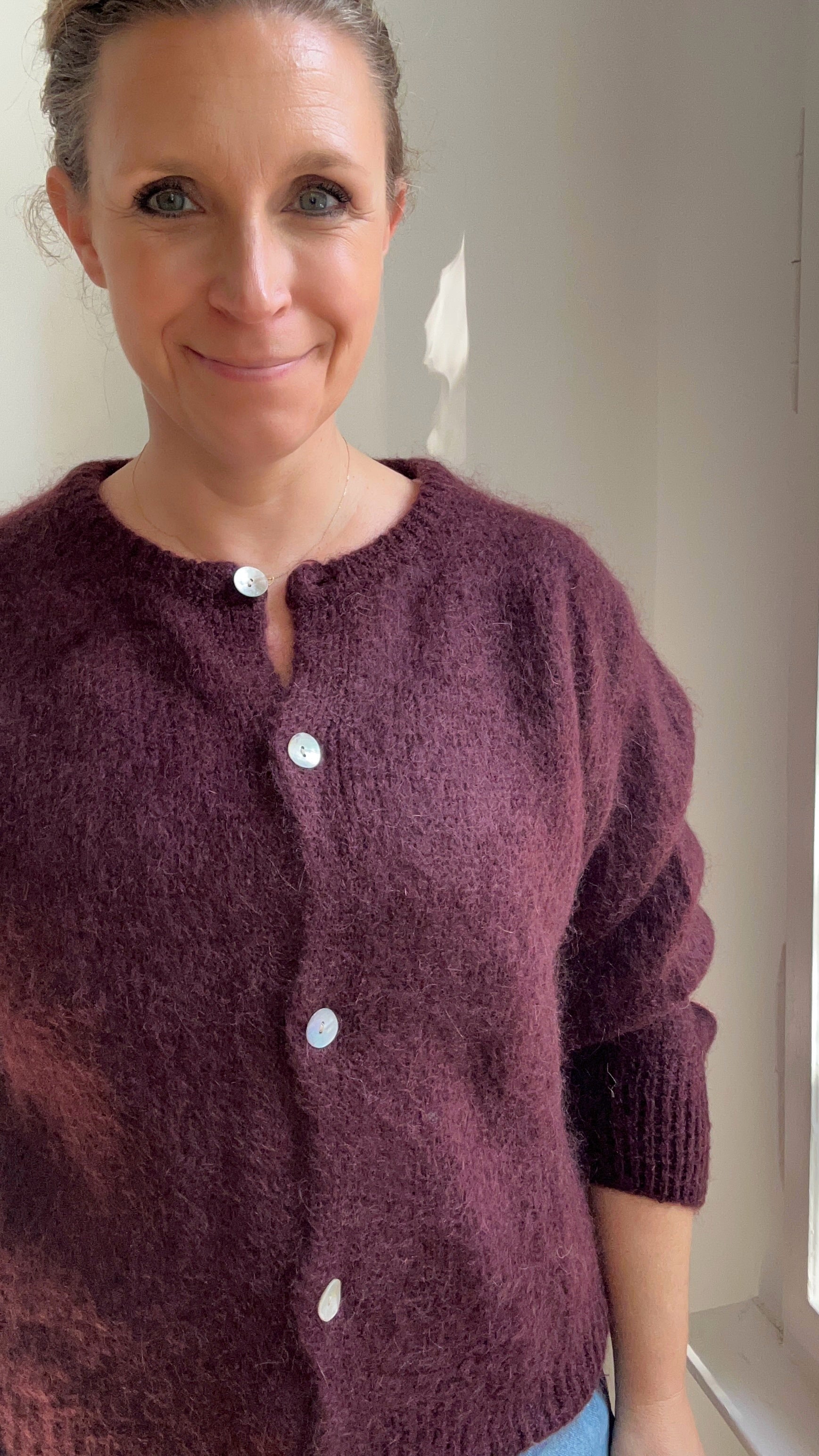 Model trägt Strickjacke Cardigan in Bordeaux kombiniert zum Alltagsoutfit