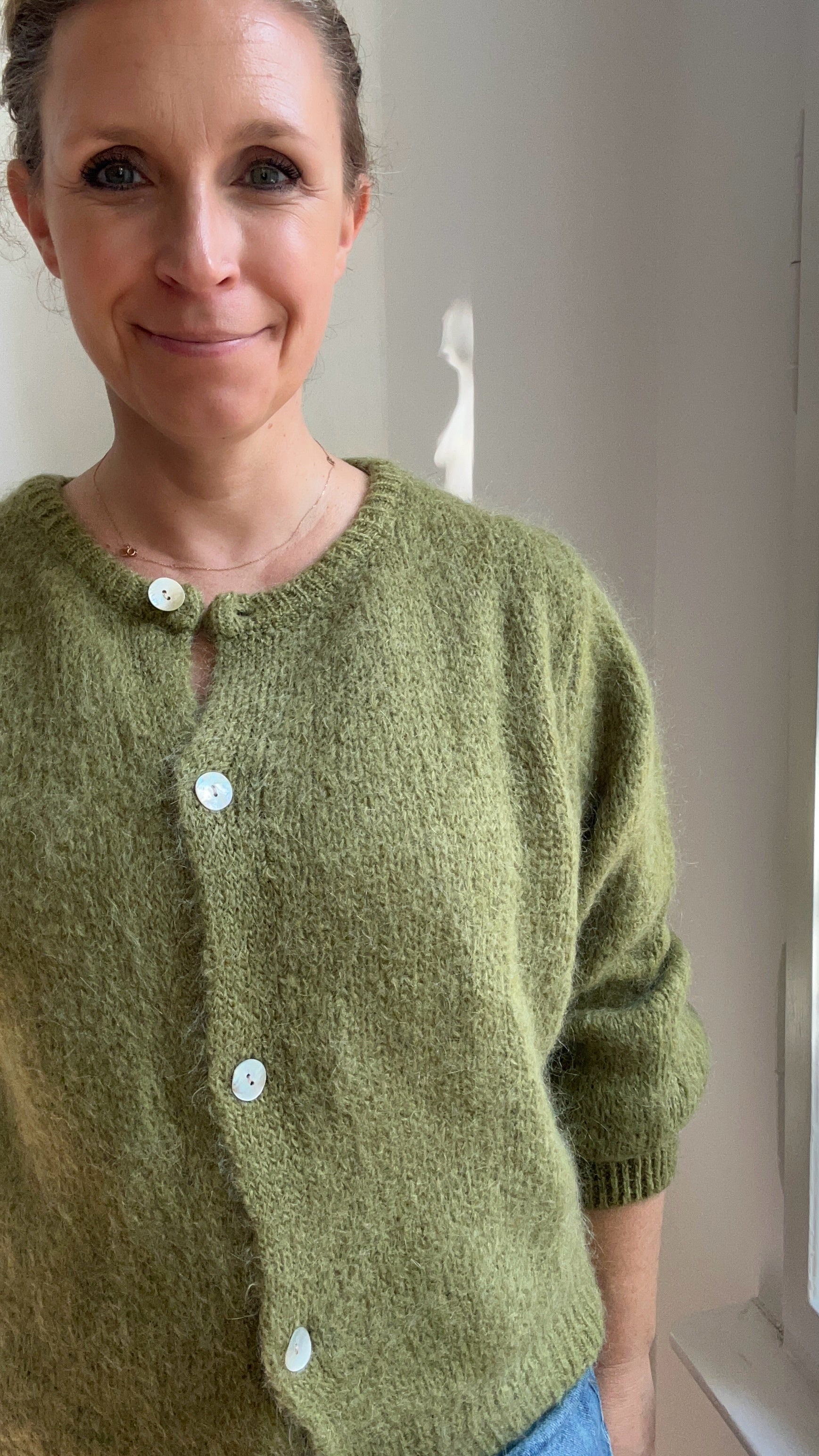 Model trägt Strickjacke Cardigan in Moosgrün kombiniert zum Alltagsoutfit