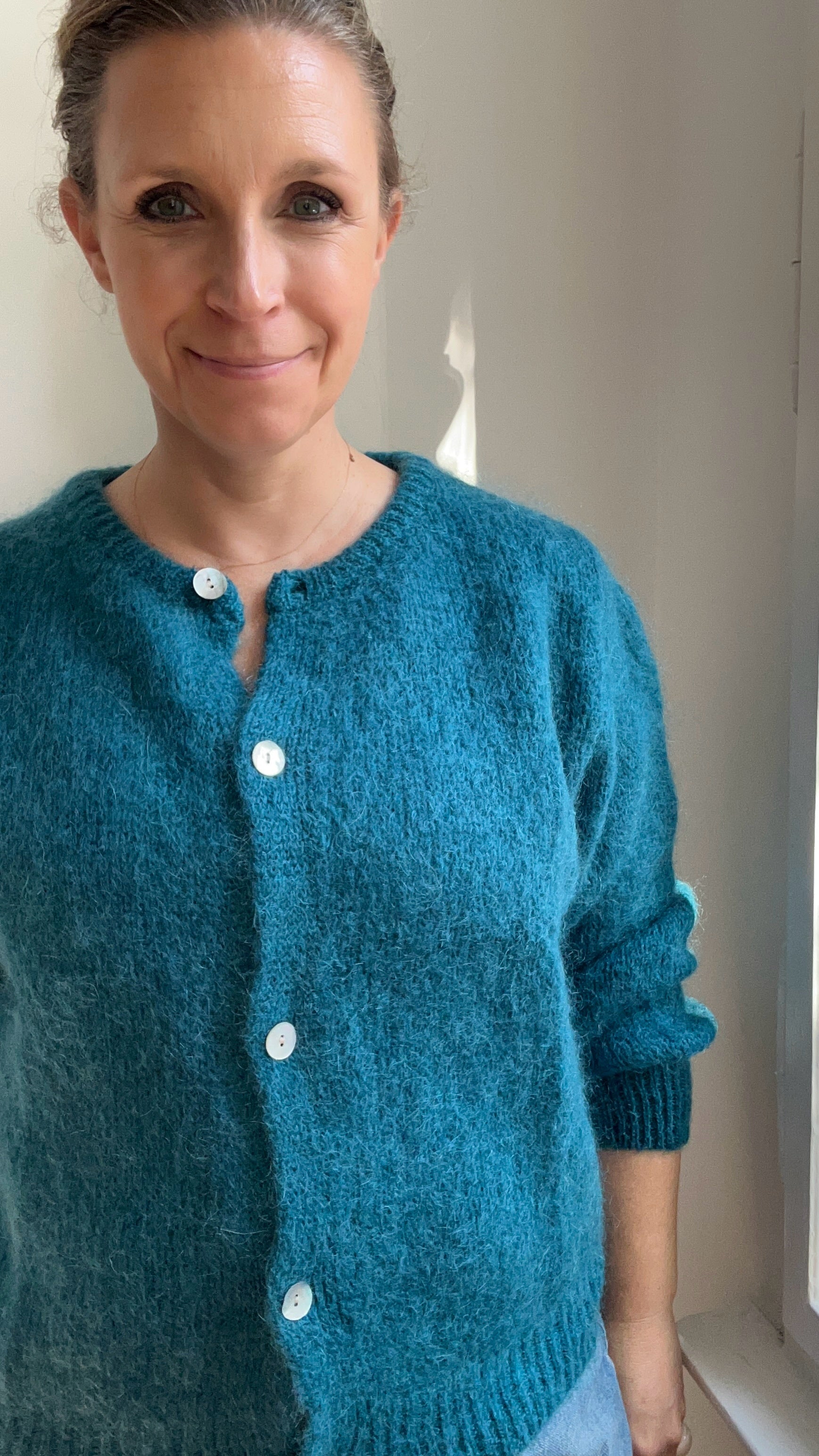 Model trägt Strickjacke Cardigan in Petrol kombiniert zum Alltagsoutfit