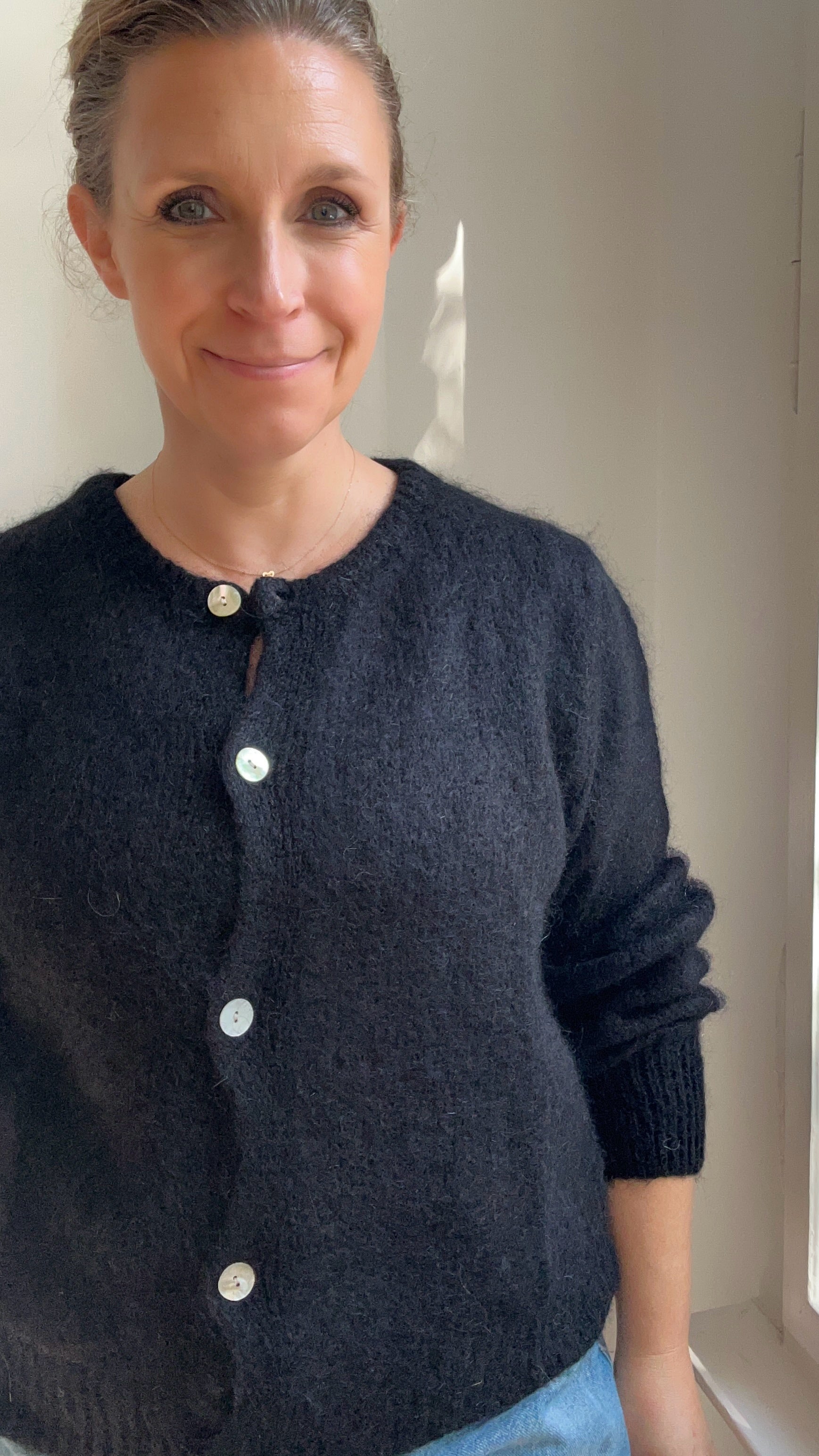 Model trägt Strickjacke Cardigan in Schwarz kombiniert zum Alltagsoutfit
