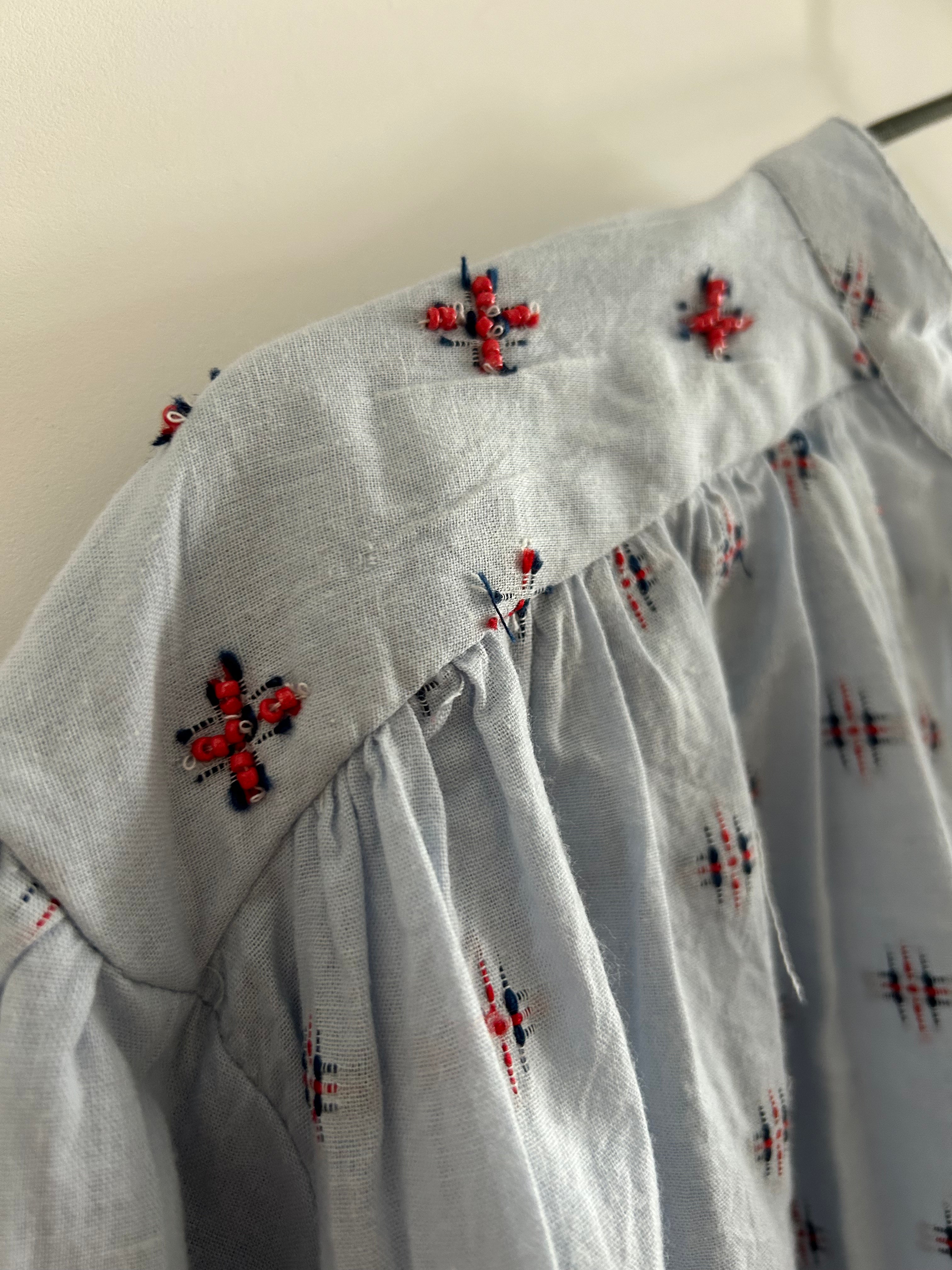 Hellblaue Bluse mit blau-rotem Muster
