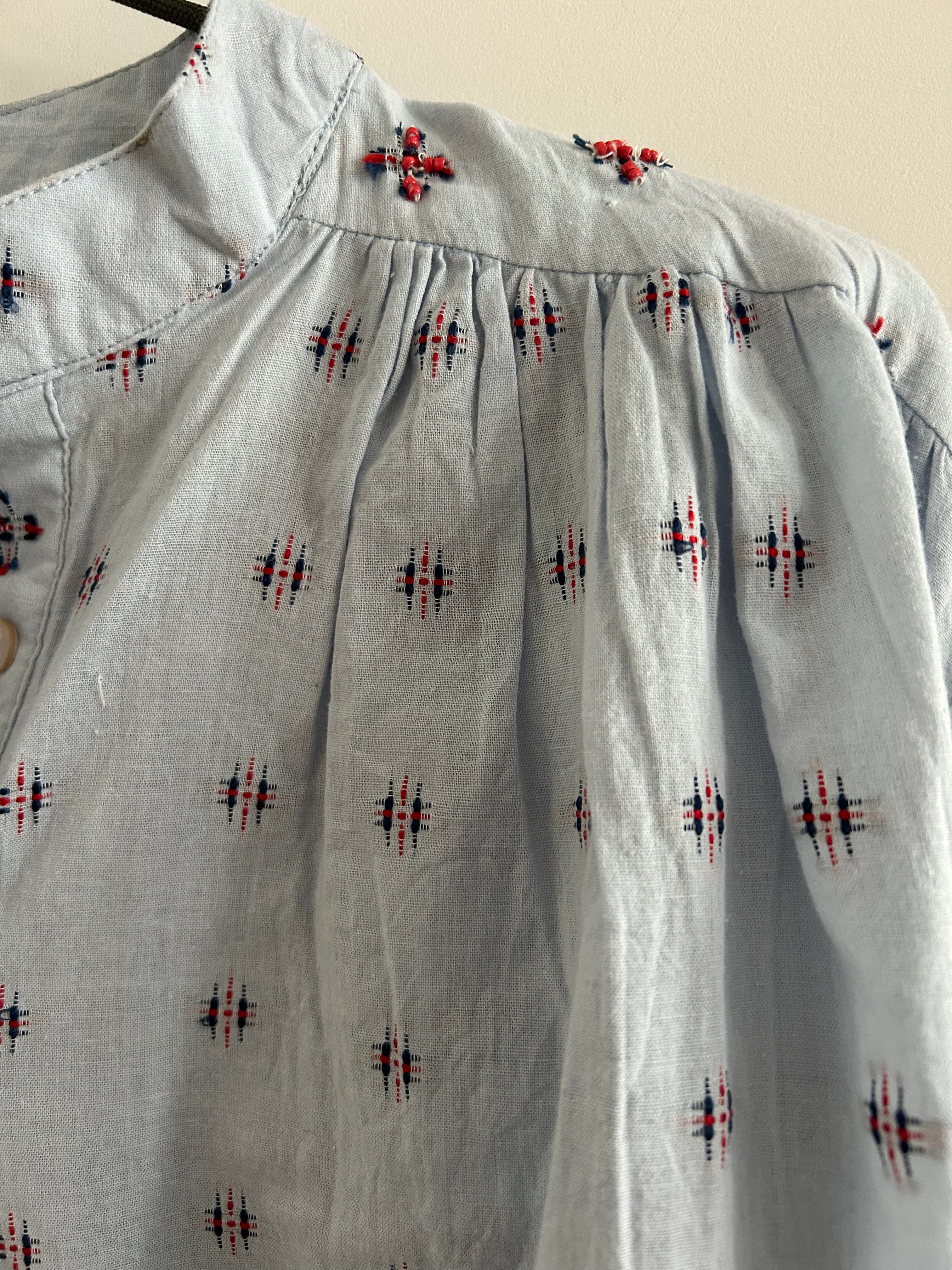 Hellblaue Bluse mit blau-rotem Muster