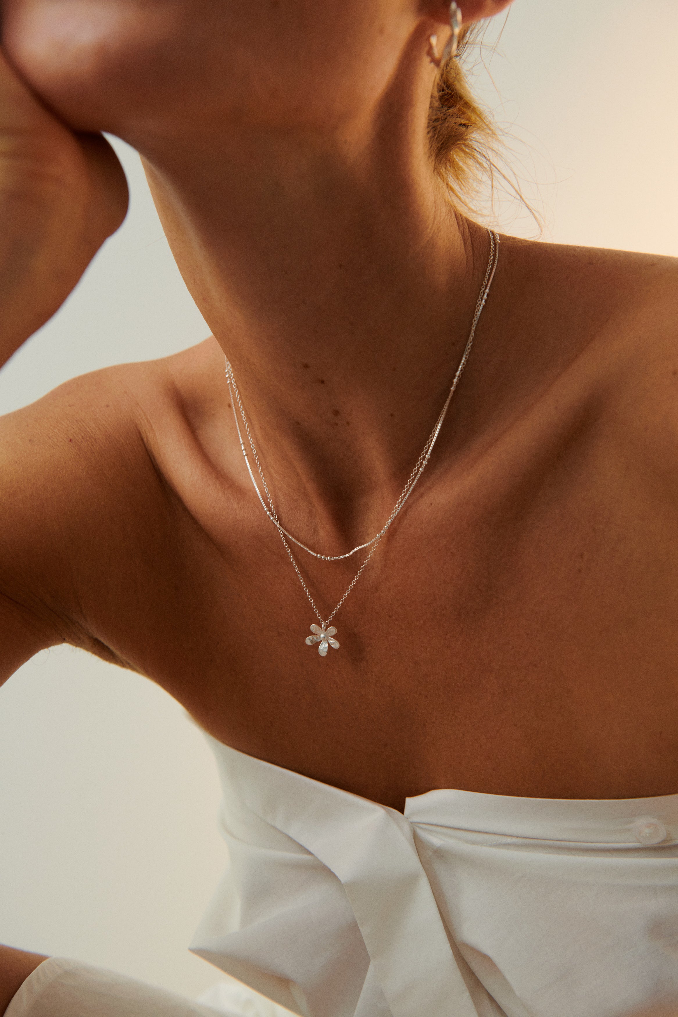 Model trägt Wild Poppy Halskette aus recyceltem Silber, zarter nachhaltiger Silberschmuck