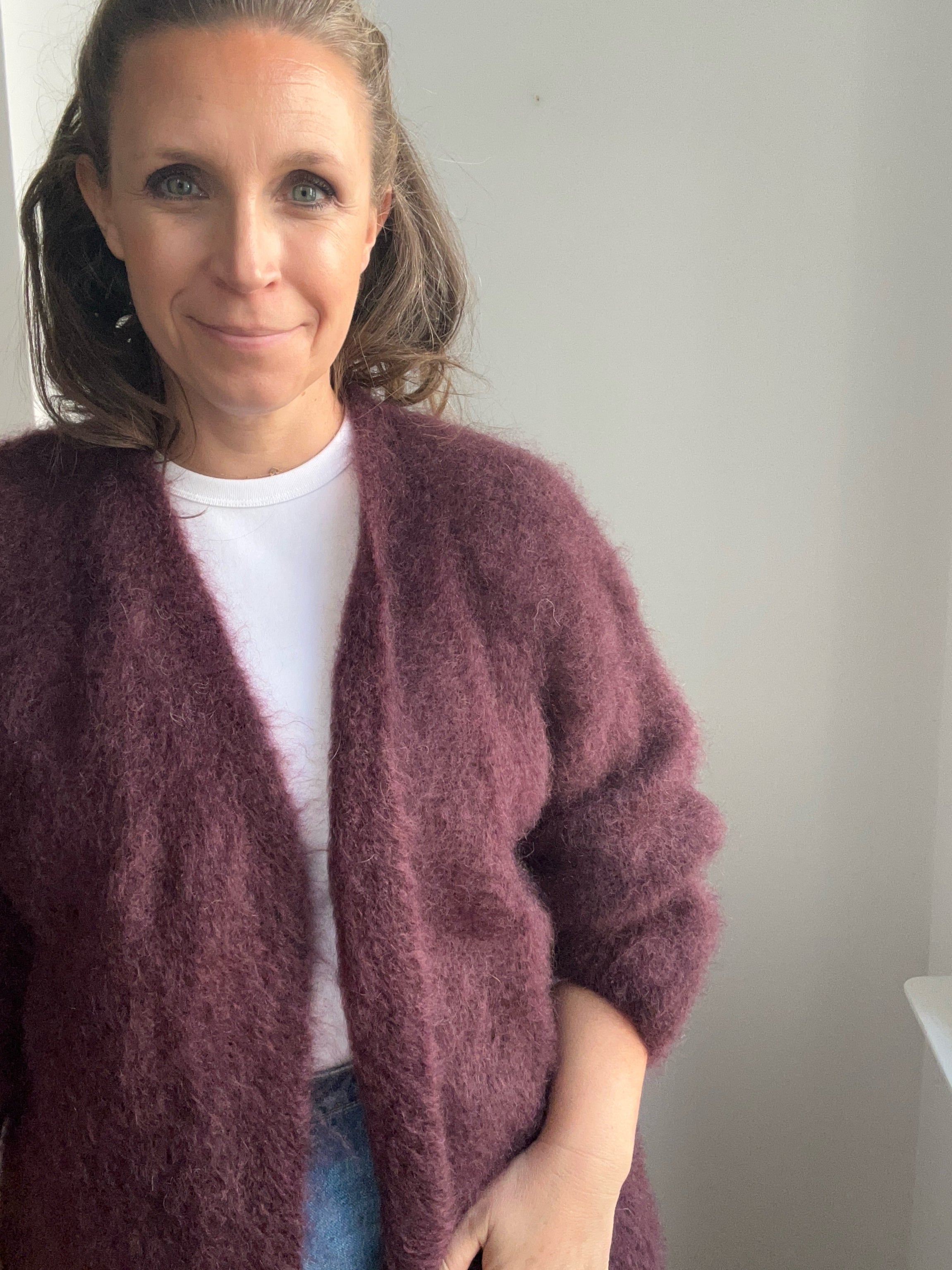 Model trägt Mohair-Strickjacke in Burgundy von Johanna Paris kombiniert zu Jeans und Bluse