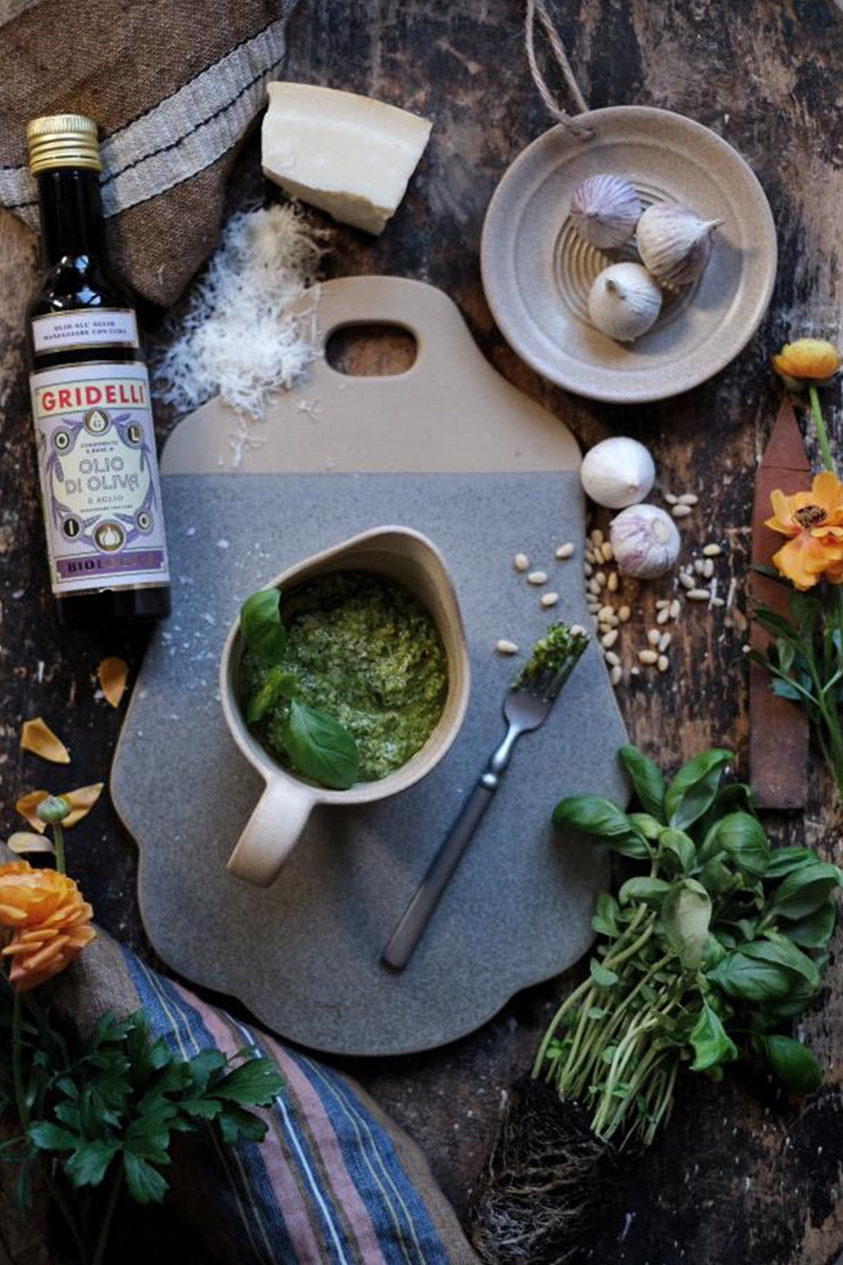 Gridelli Olio e Aglio Bio Olivenöl auf Küchentisch neben Knoblauch und Käse