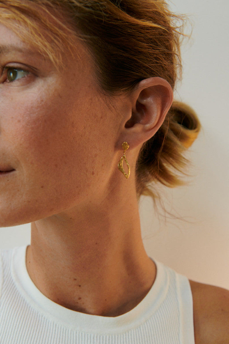 Goldene Flowing Dreams Ohrringe von Pernille Corydon am Ohr getragen – organische Form