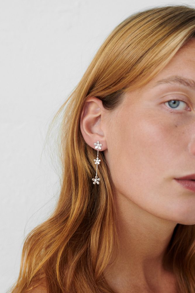 Frau trägt vergoldete Wild Poppy Ohrringe aus recyceltem Silber im skandinavischen Design von Pernille Corydon