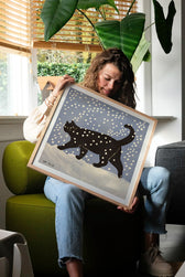 Kunstdruck Snow Cat von Enikő Eged gerahmt an einer Wohnzimmerwand als stimmungsvolle Dekoration