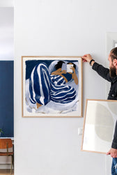 Kunstdruck The Blue Hour von Marco Marella mit lesender Frau als Wanddeko im Wohnzimmer