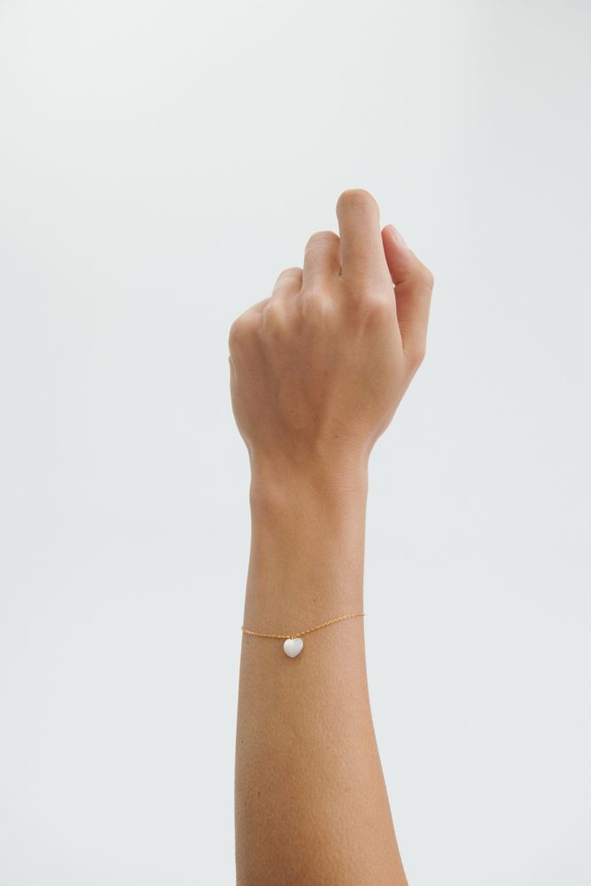 Model trägt das goldene Ocean Heart Armband von Pernille Corydon mit Perlmutt