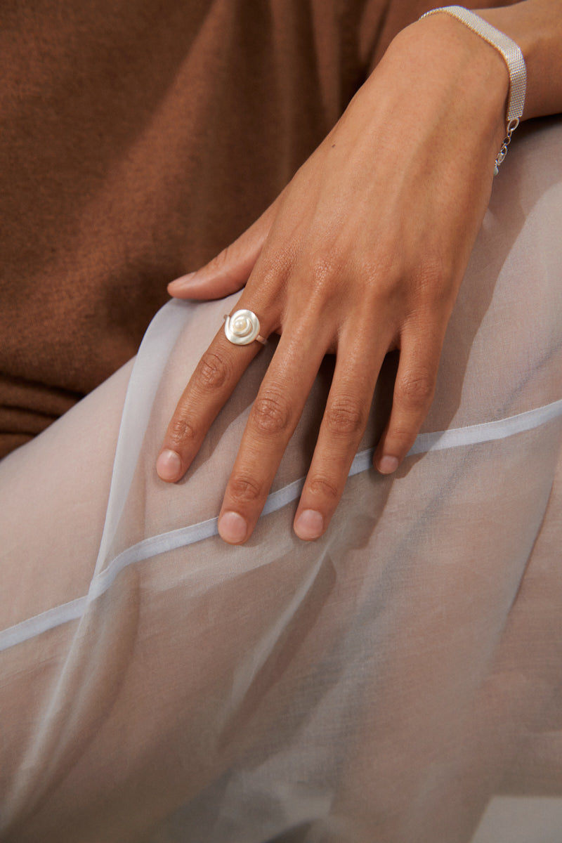 Nahaufnahme Shell Flower Ring mit spiralförmigem Design und Perle